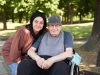 Pflegekraft und Senior im Rollstuhl im Park