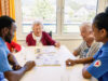 Pflegepersonal mit Bewohnerinnen beim Spielen im Haus Eichholzgärten