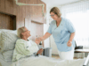 Pflegefachkraft reicht Patientin Wasserglas