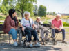 Pflegerin sitzt mit Senioren im Park
