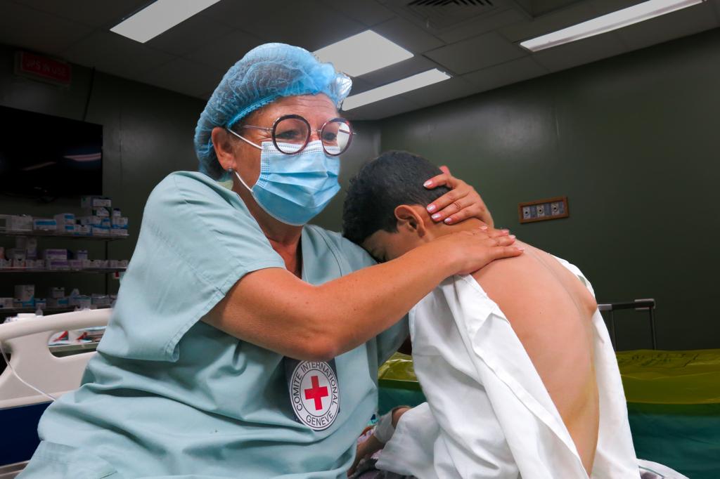 Susanne Serry hält ein Kind im Arm bei einem Einsatz im Gaza Streifen 2023