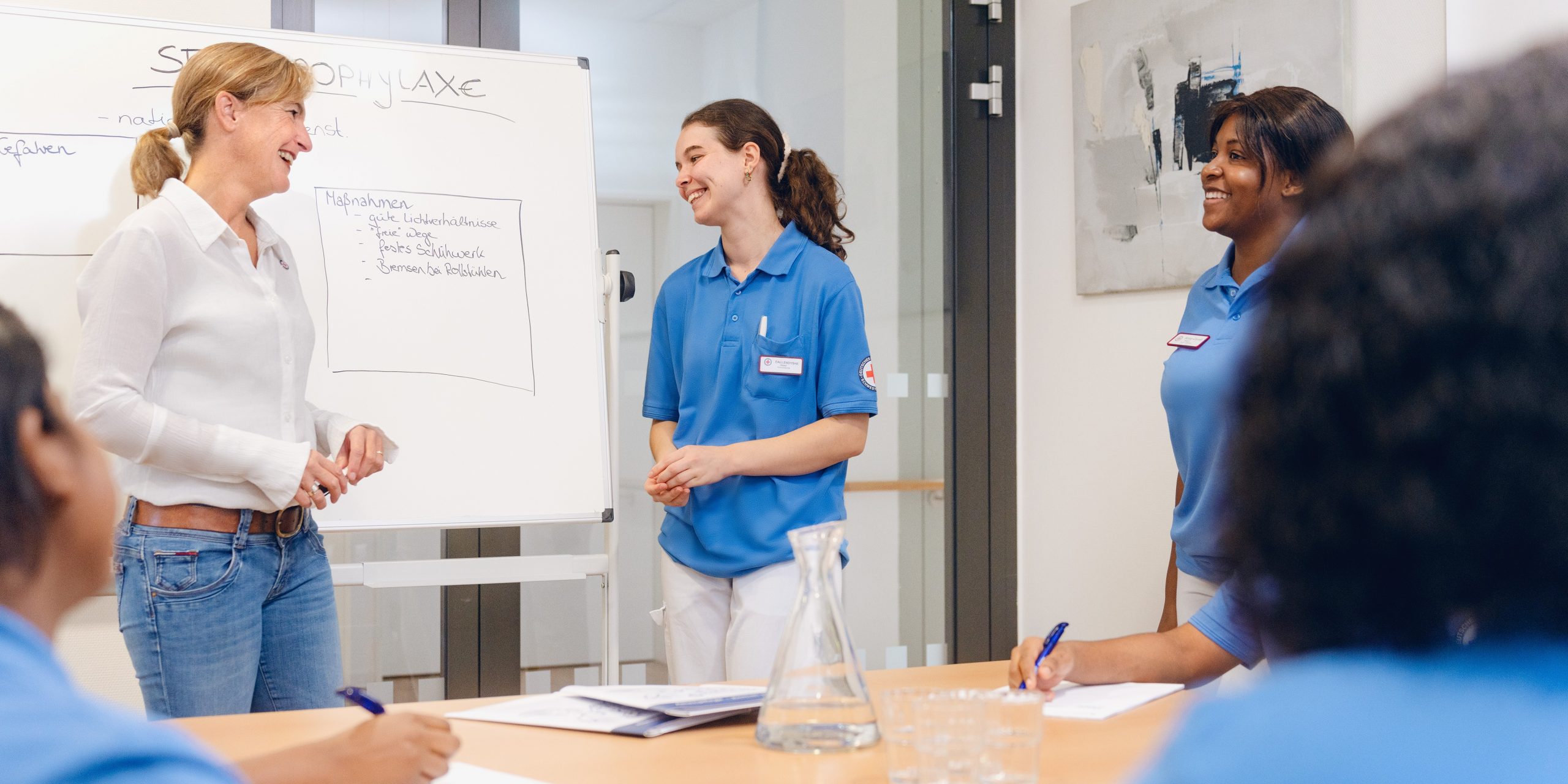 Oberin Anne-Katrin Gerhardts vor einem FlipChart mit Auszubildenden im Gespräch